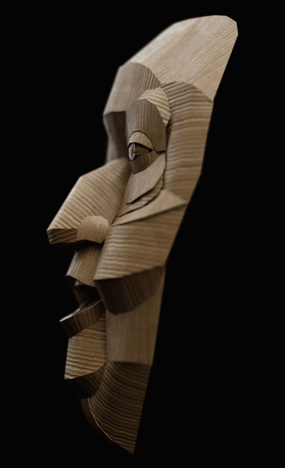A carved wooden mask sculpture of a long stylised face, on black