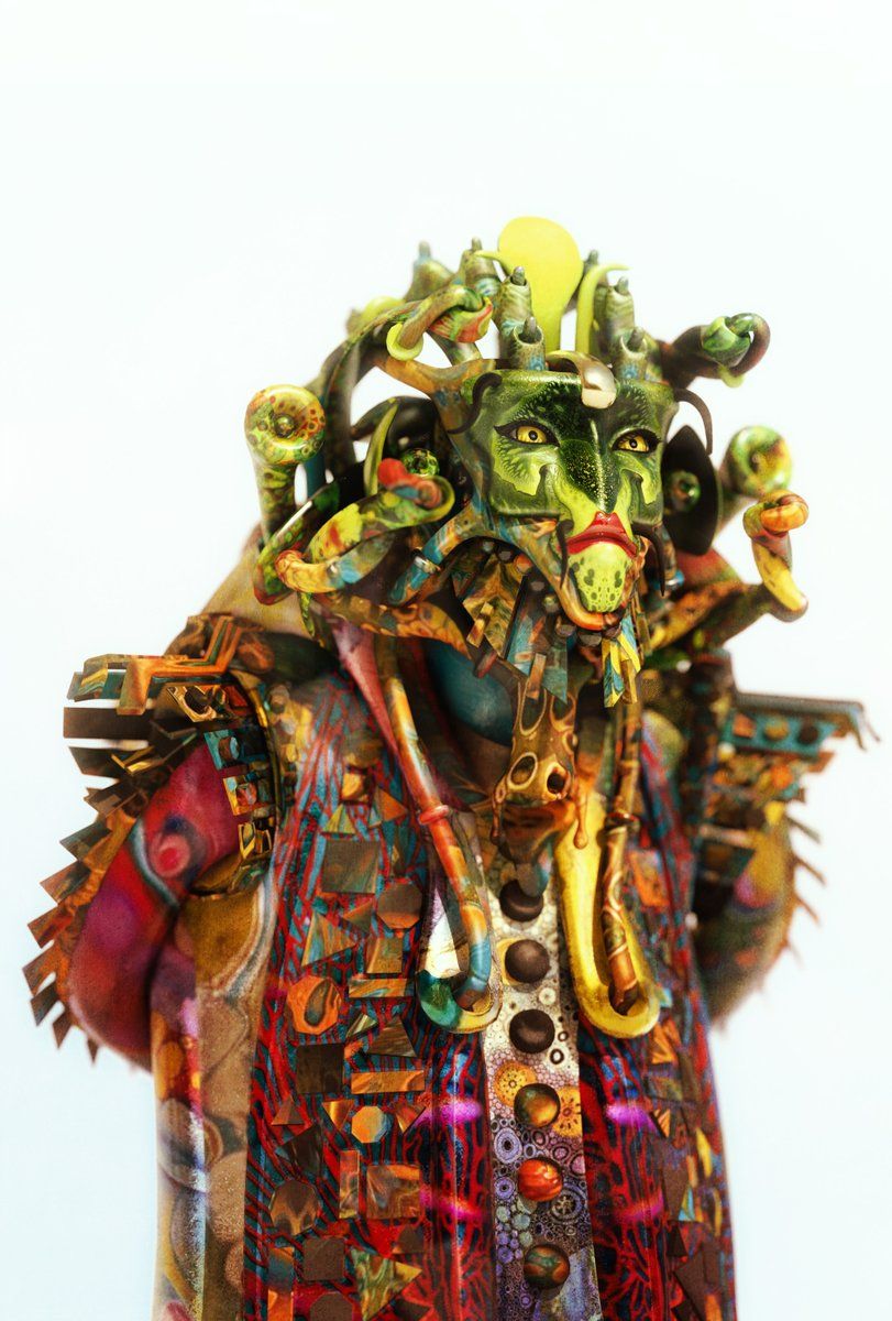 A colourful costumed figure covered in flowers, fruit and ornaments, on a white background